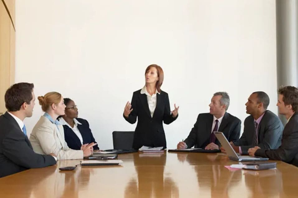 A woman standing in front of a group of people.