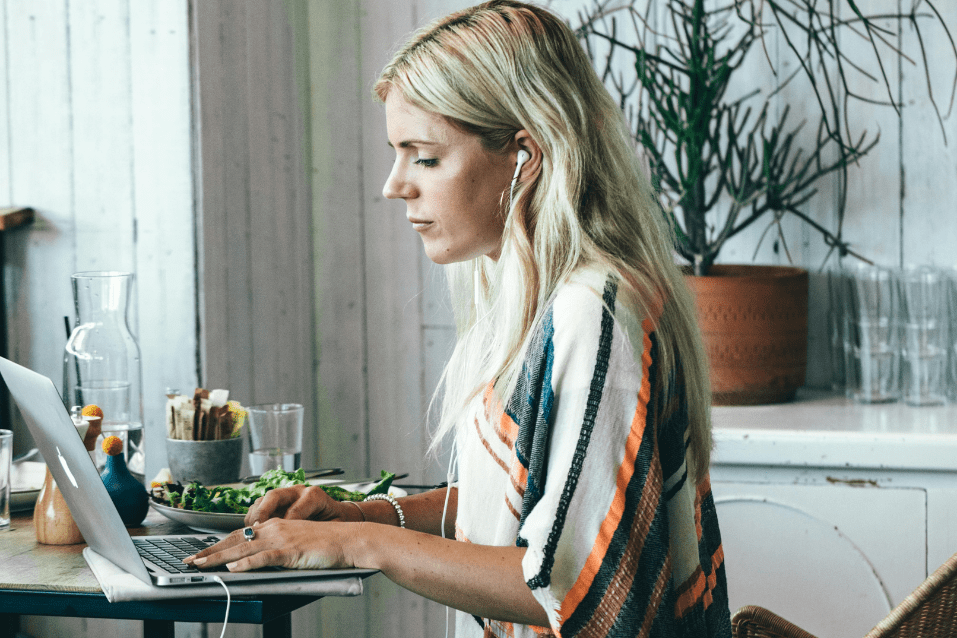 A woman sitting at a table with a laptop.