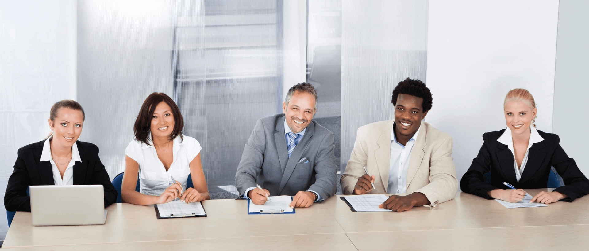 Three people sitting at a table with papers.