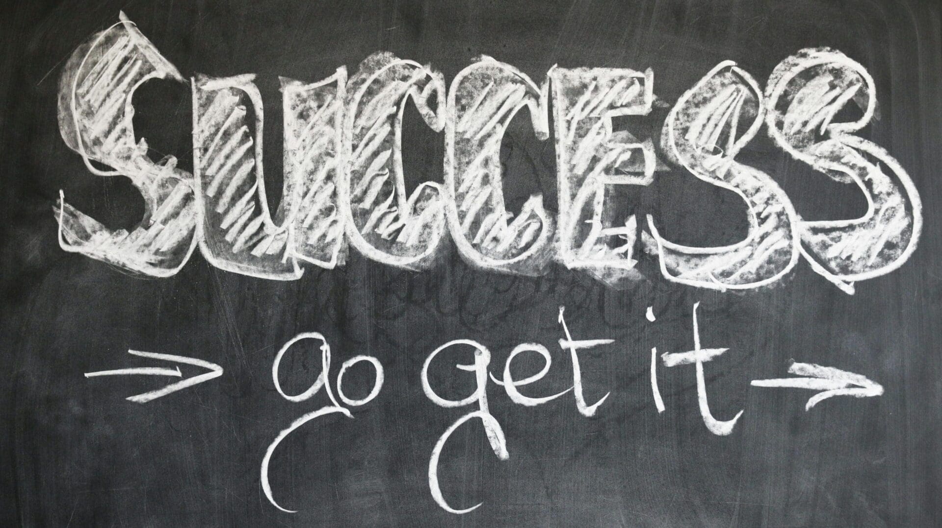 A chalkboard with the word success written in chalk.